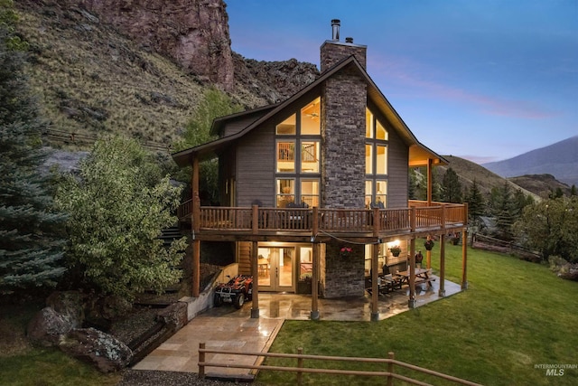 9 Autumn Blaze Ln, Salmon, ID 83467 - back of house with a chimney, a deck with mountain view, a patio, a yard, and french doors
