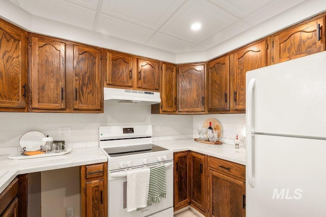 122 N Washington, Moscow, ID 83843 - kitchen featuring brown cabinetry, white appliances, light countertops, and under cabinet range hood