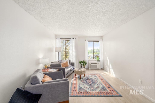 122 N Washington, Moscow, ID 83843 - living room featuring cooling unit, a textured ceiling, baseboards, and light wood-type flooring