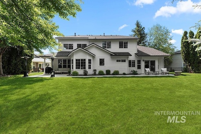 back of house featuring a patio and a shingled roof