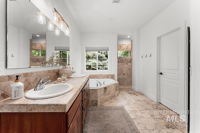 full bathroom with healthy amount of natural light, a bath, a walk in shower, and double vanity