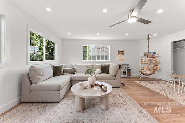living room featuring healthy amount of natural light, recessed lighting, light wood finished floors, baseboards, and a ceiling fan
