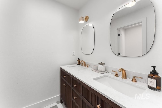 bathroom featuring double vanity and baseboards