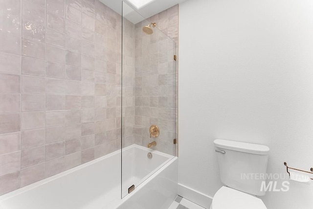 bathroom with toilet, baseboards, and shower / washtub combination
