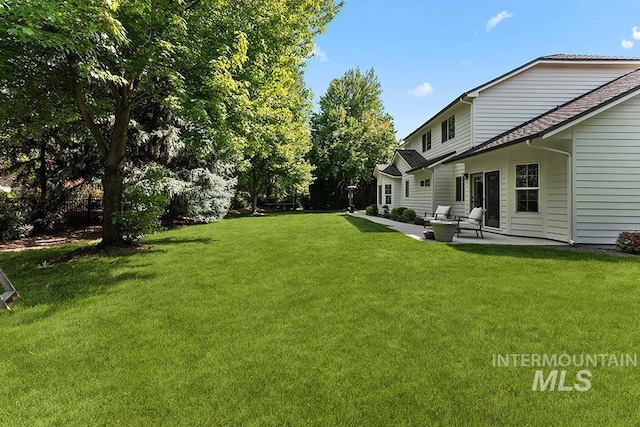 view of green lawn with a patio