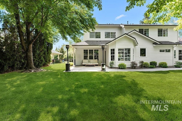 back of house featuring a patio and a lawn