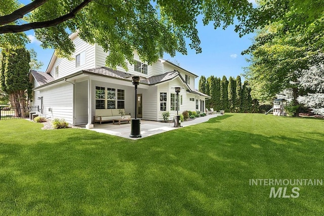 rear view of property featuring a patio area, a yard, an outdoor living space, and a playground