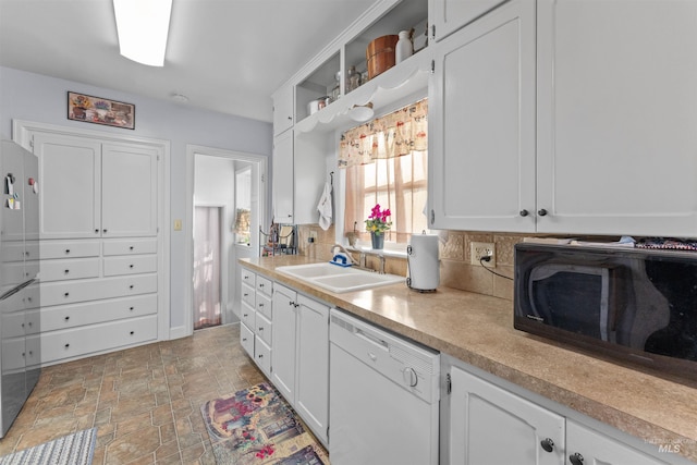 kitchen featuring decorative backsplash, dishwasher, white cabinets, and sink