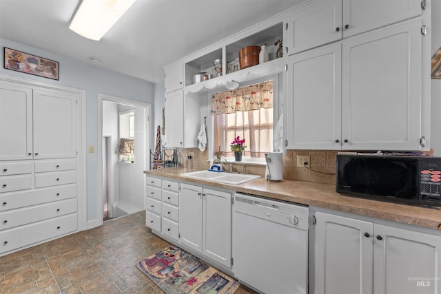 kitchen with decorative backsplash, white cabinetry, sink, and white dishwasher