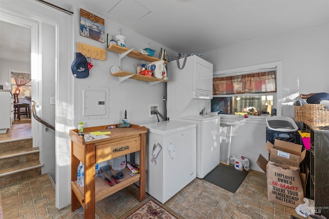 laundry room featuring electric panel and stacked washer and dryer