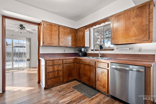 kitchen featuring ceiling fan, stainless steel dishwasher, light hardwood / wood-style floors, and sink