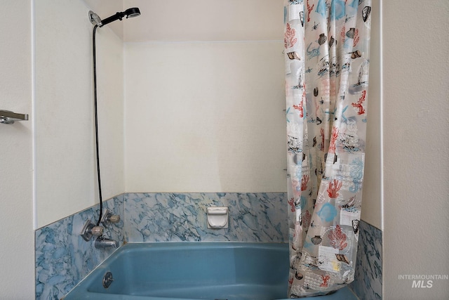 bathroom with shower / bath combo with shower curtain