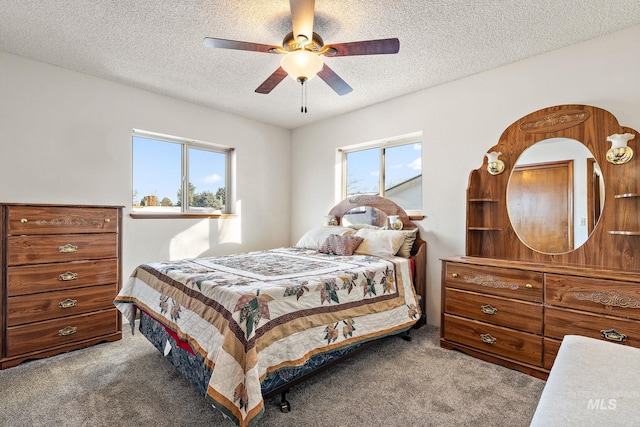 bedroom featuring multiple windows, a textured ceiling, and carpet