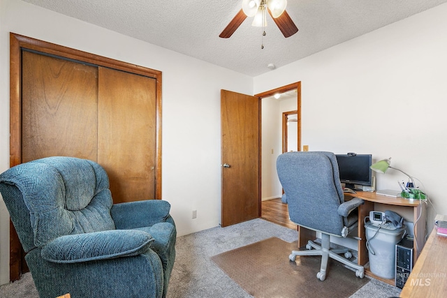 office featuring ceiling fan, light colored carpet, and a textured ceiling