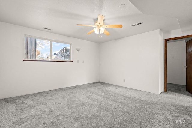 empty room with a textured ceiling, ceiling fan, and carpet flooring