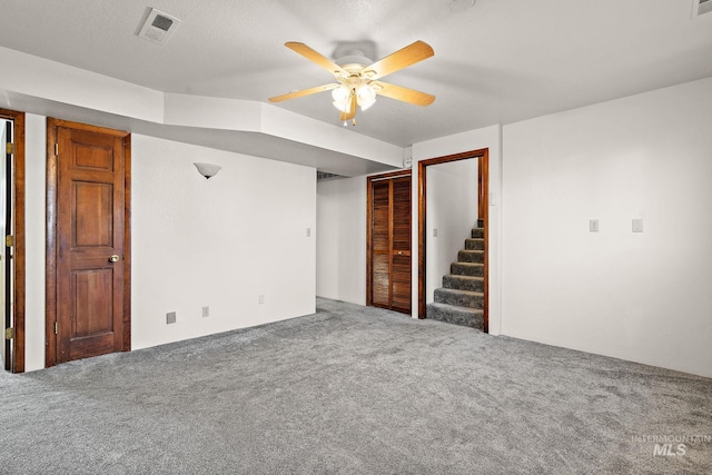 interior space featuring carpet, a textured ceiling, and ceiling fan