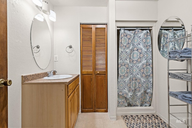 bathroom with walk in shower, tile patterned floors, and vanity