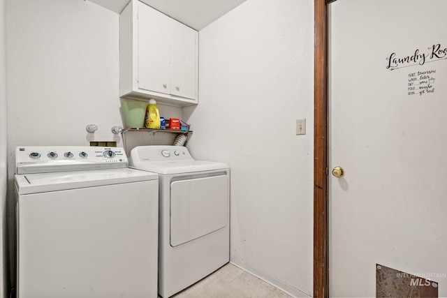 laundry area featuring light tile patterned flooring, cabinets, and washing machine and clothes dryer