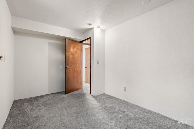 carpeted spare room with a textured ceiling