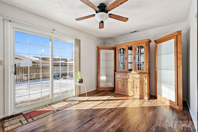 doorway to outside featuring ceiling fan, light hardwood / wood-style flooring, and a textured ceiling