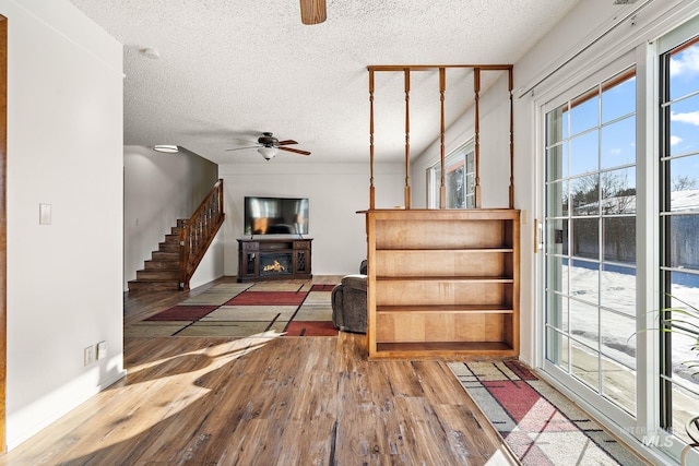 interior space with ceiling fan, hardwood / wood-style floors, and a textured ceiling