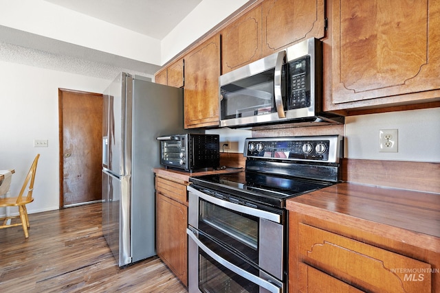 kitchen with stainless steel appliances and light hardwood / wood-style flooring