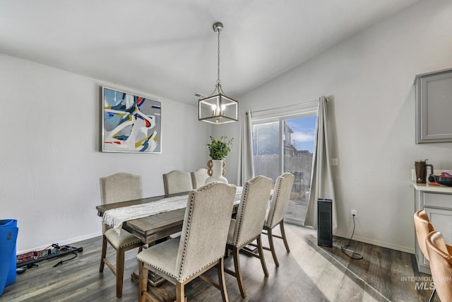 dining space with an inviting chandelier, vaulted ceiling, and dark hardwood / wood-style flooring