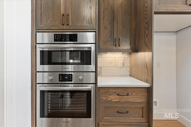 kitchen with decorative backsplash and stainless steel double oven