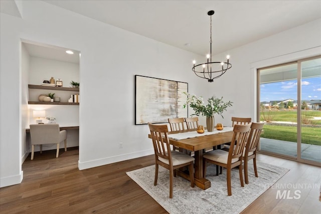 dining area with a chandelier, baseboards, and wood finished floors