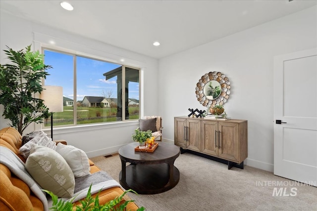 living area with recessed lighting, light colored carpet, visible vents, and baseboards