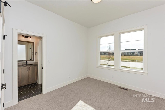 carpeted spare room featuring sink