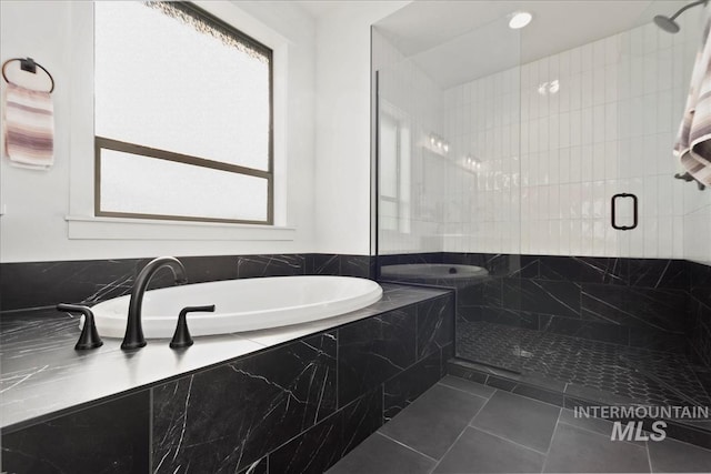 full bathroom with a stall shower, a garden tub, and tile patterned floors