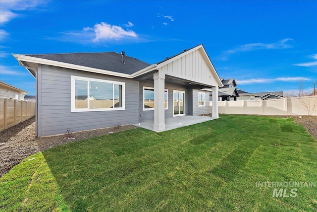 back of house with a patio area and a yard