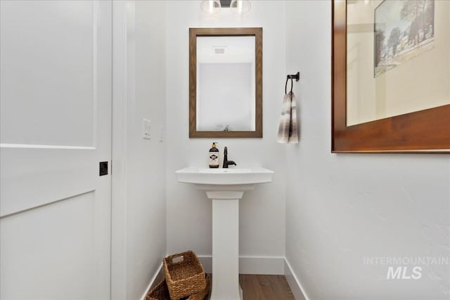 bathroom with baseboards and wood finished floors