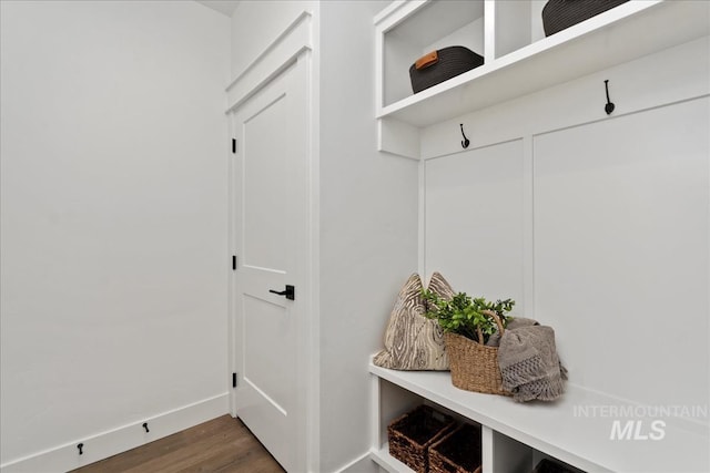 mudroom featuring dark wood-type flooring and baseboards