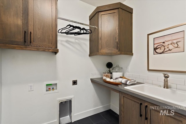 washroom with hookup for a washing machine, cabinet space, hookup for an electric dryer, a sink, and baseboards