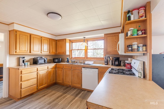 kitchen with white appliances, sink, ornamental molding, light hardwood / wood-style floors, and kitchen peninsula