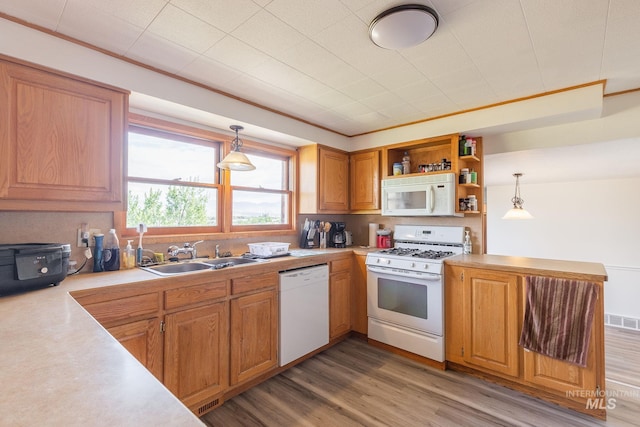 kitchen with hardwood / wood-style flooring, sink, white appliances, and hanging light fixtures