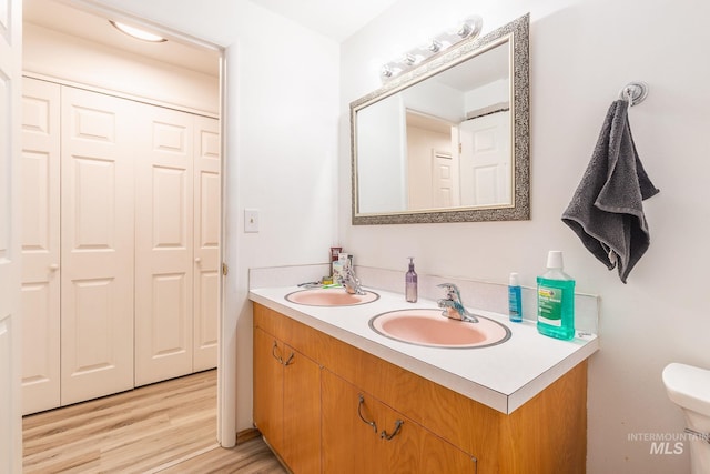 bathroom with hardwood / wood-style flooring, vanity, and toilet