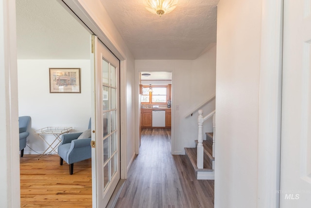 hallway with hardwood / wood-style flooring and a textured ceiling