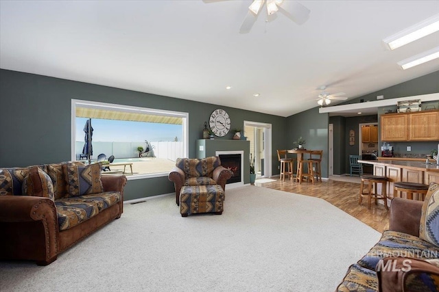 323 W 100 N, Jerome, ID 83338 - living area with wood finished floors, vaulted ceiling, a warm lit fireplace, and ceiling fan