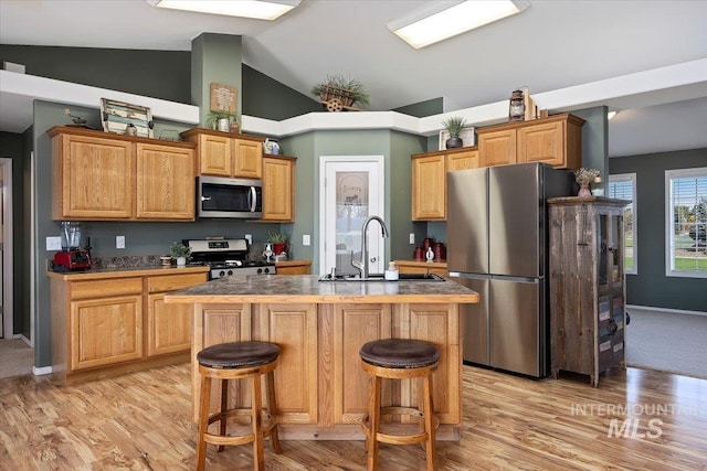 323 W 100 N, Jerome, ID 83338 - kitchen with a breakfast bar, an island with sink, light wood-style floors, appliances with stainless steel finishes, and a sink