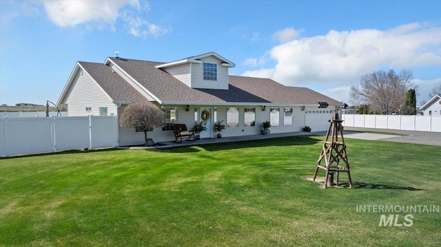 323 W 100 N, Jerome, ID 83338 - back of house with driveway, a garage, fence, and a lawn