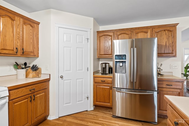 kitchen with stainless steel fridge with ice dispenser and light hardwood / wood-style floors