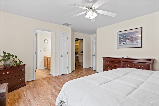 bedroom featuring ensuite bath, ceiling fan, light hardwood / wood-style flooring, and a closet