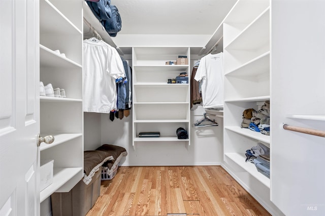 walk in closet with light hardwood / wood-style floors