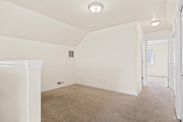 bonus room with light colored carpet and lofted ceiling