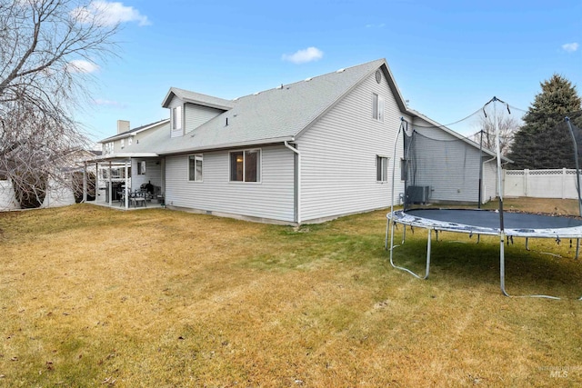 back of house with a lawn, central AC unit, a trampoline, and a patio