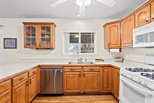 kitchen with white appliances, ceiling fan, light hardwood / wood-style flooring, and sink