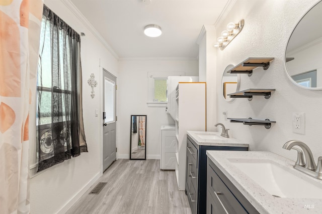 1035 Francis St, Clarkston, WA 99403 - washroom featuring ornamental molding, light wood-type flooring, and washer and clothes dryer